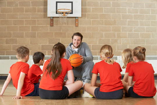 Coach Giving Team Talk To Elementary School Basketball Team