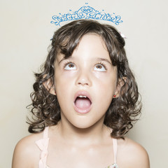 Niña con gesto de sorpresa y corona de princesa pintada