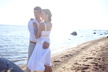 Just married happy couple running on a sandy beach