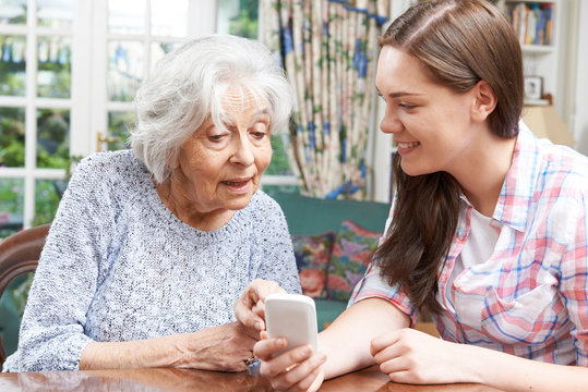 Teenage Granddaughter Showing Grandmother How To Use Mobile Phon