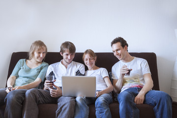 Group of friends laughing with laptop