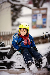 Happy little kid is playing in snow, good winter weather