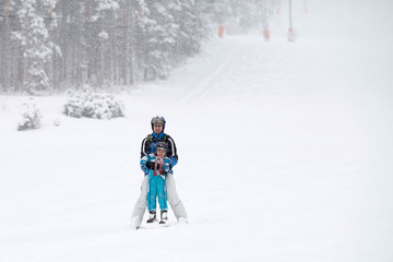 Father and son, skiing in the winter, boy learning to ski