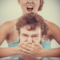 fury woman screaming while covering mouth her man