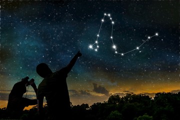 Dragon constellation on night sky. Astrology concept. Silhouettes of adult man and child observing...