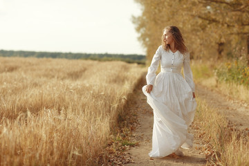 Fototapeta na wymiar girl dancing in a field in white dress