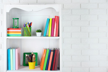 Books and decor on shelves in cupboard © Africa Studio