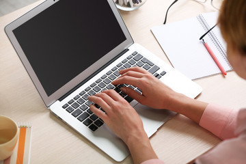 Fototapeta na wymiar Woman using laptop on workplace close up