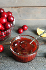 Tasty homemade plum jam on wooden background