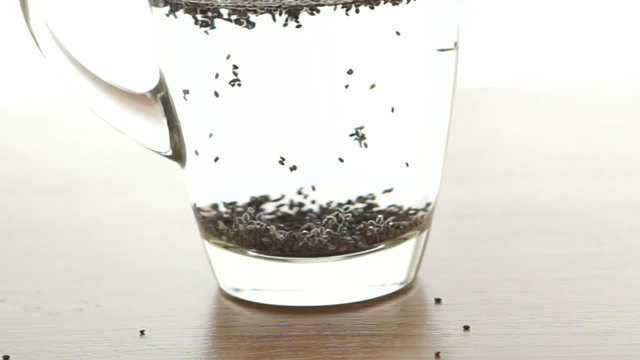 Chia seeds soak up in water glass on white background