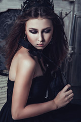 Fototapeta na wymiar Young girl in gothic dress with black rose