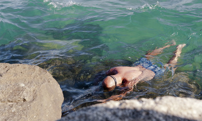 a man floating facedown on the water looking for sea-hedgehog