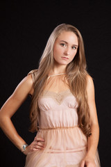 Naklejka premium Pretty woman with long hair, looking thoughtful with her hand on her hip