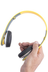 right hand holding yellow headphone