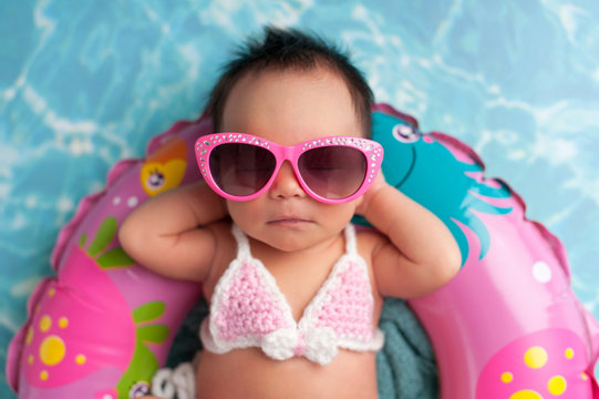 Newborn Baby Girl Wearing Sunglasses and a Bikini Top