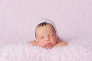 Newborn Baby Girl Wearing a Pink Knitted Bonnet