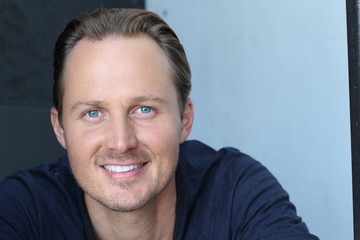 Laughing gorgeous guy with blond hair and blue eyes