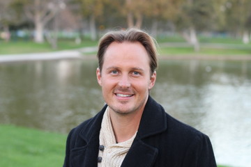 Young handsome man with lake in background in the winter 