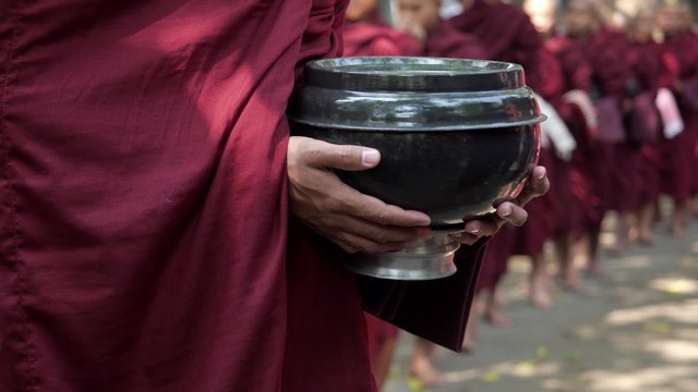 Unrecognizable Buddhist monks walking in line at Mahagandayon Monastery in Amarapura, Mandalay, Myanmar (Burma).