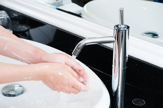 洗面台で手を洗っている,女性の手