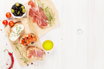 Bruschetta with cheese, tomatoes and prosciutto