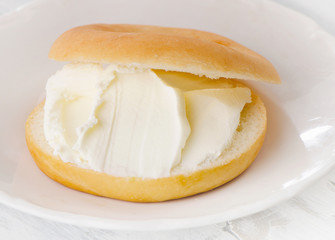 Plate with sliced bagel and cream cheese.
