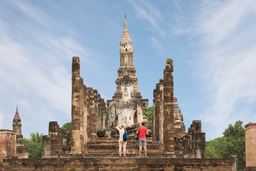 Obraz premium Foreign Tourists are taking photo of Ancient Buddha at Sukhothai