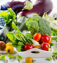 Fresh organic vegetables on white wooden table.