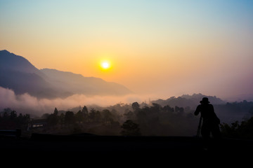 Silhouette of a photographer taking picture on landscape.