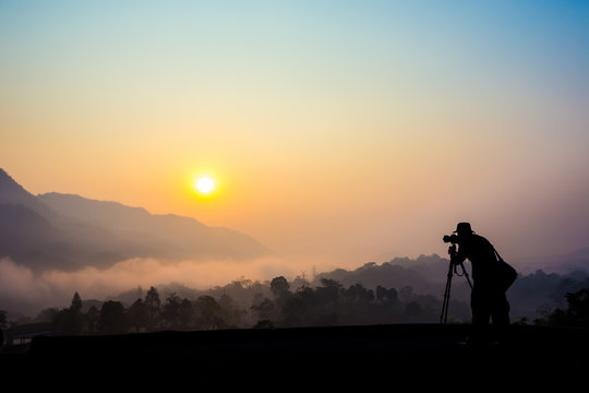 Silhouette of a photographer taking picture on landscape.