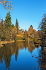 Manor house by the river in autumn landscape
