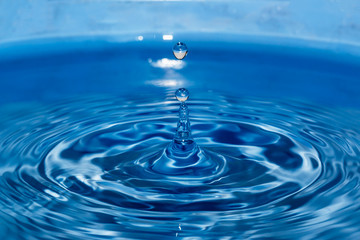 Naklejka na ściany i meble Water droplets higher on blue background