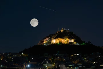 Poster Lycabettus mountain in Athens Greece against the August full moon and a falling star.   © Bill Anastasiou
