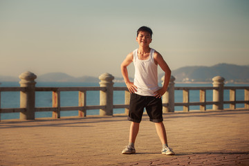 vietnamese boy bends downward on embankment at dawn