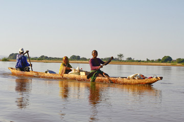 Malagasy people crossing the inlets in an outrigger canoe