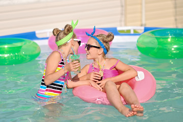 Portrait of two girls in a swimming pool