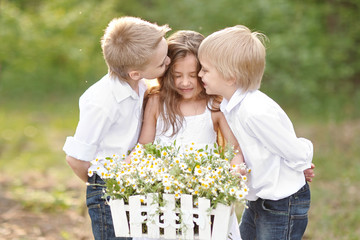 three children playing on meadow in summer