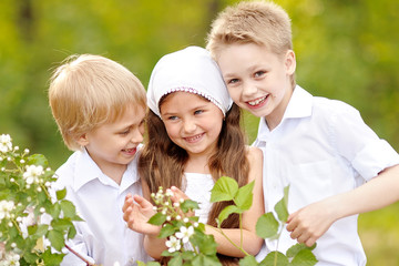 three children playing on meadow in summer