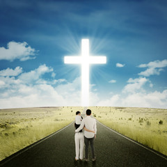 Family standing on the way with a cross