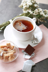 Cup of flavored coffee with chocolate on table with napkin, closeup