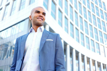 Pleasant businessman standing near office 