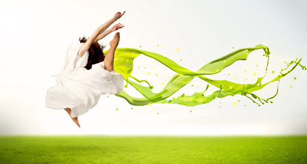 Pretty girl jumping with green abstract liquid dress