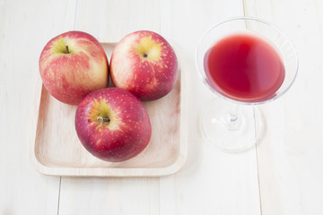 Apple and fruit juices in wine glass on wooden background