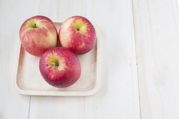 Apple on wooden dish on wooden background