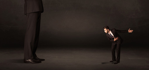 Fototapeta premium Huge man with small businessman standing at front concept