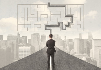Businessman looking at road with maze and solution