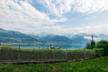 Fototapeta premium Laghetto di Piona in Italy, Alps, Europe. Como lake landscape, clouds, mountains and gardens.