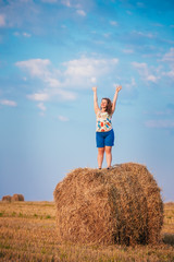 Naklejka na ściany i meble Beautiful Plus Size Young Woman Girl Is Standing On A Haystack W