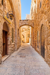 Narrow street among old stone walls of Jewish Quarter in Jerusal