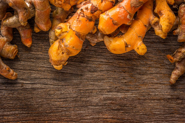 Stack of turmeric on grunge wooden background.